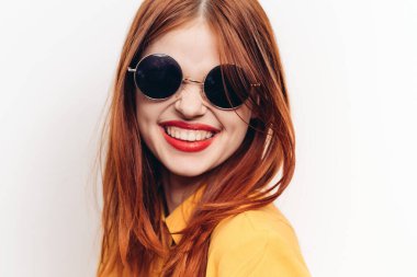 Güneş gözlüklü, kızıl saçlı, çekici bir kadın.