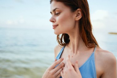 Plaj adasında mavi mayo giymiş bir kadın.