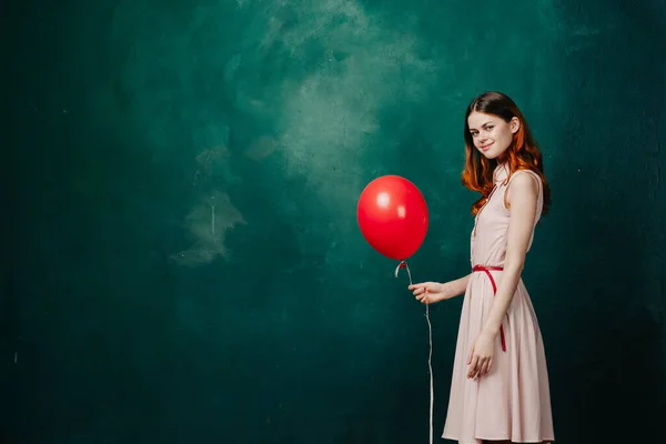 Wanita dengan balon merah pada liburan latar belakang hijau menyenangkan — Stok Foto