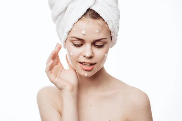 Веселая женщина с белым полотенцем на голове крем для лица уход за кожей — стоковое фото