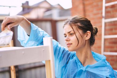 Kadın boyacı evde ahşap döşemeleri yeniliyor.