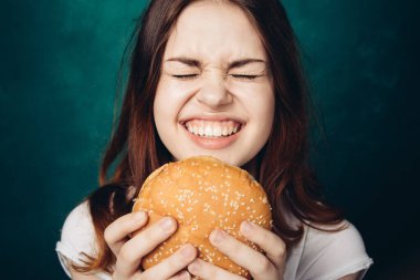 Hamburger yiyen bir kadın.