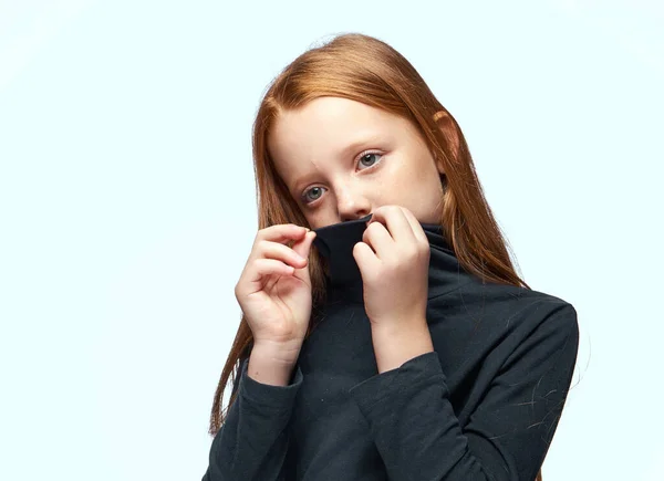 Chica pelirroja en un jersey negro planeando de cerca —  Fotos de Stock