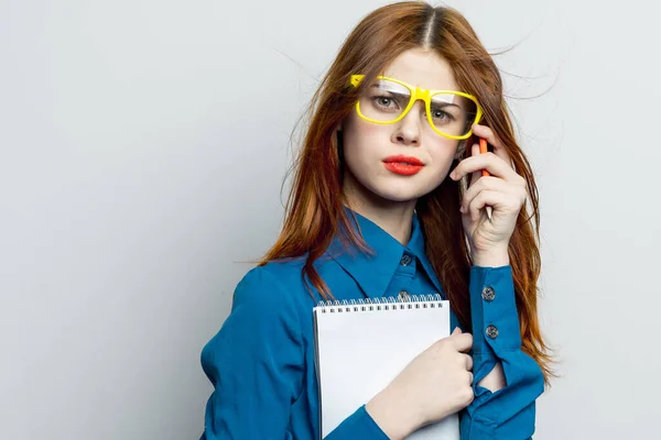 Femme d'affaires avec bloc-notes et crayon portant des lunettes jaunes bureau professionnel — Photo