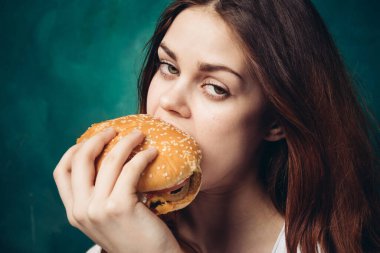Hamburger yiyen bir kadın.