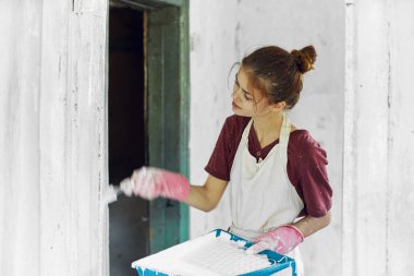 Oda dekorasyonunda fırça boyalı kadın ressam.