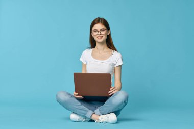 Dizüstü bilgisayarı olan kadın internet eğitimi mavi arka plan