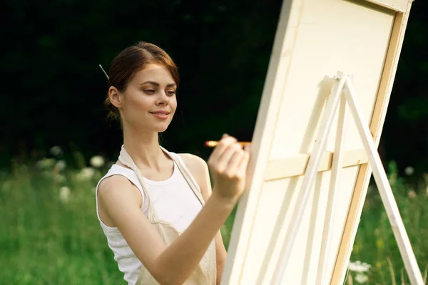 Γυναίκα καλλιτέχνης ζωγραφίζει μια εικόνα κοντά easel εξωτερικό τοπίο δημιουργική — Φωτογραφία Αρχείου