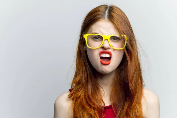 Hübsche Frau gelbe Brille und rote Lippen Mode Licht Hintergrund — Stockfoto