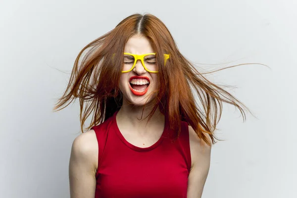 Emotionele vrouw in rode jurk gele bril poseren — Stockfoto
