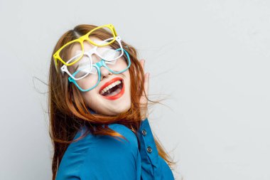 Yüzünde mavi gömlekli, göz kamaştırıcı gözlüklü bir kadın.