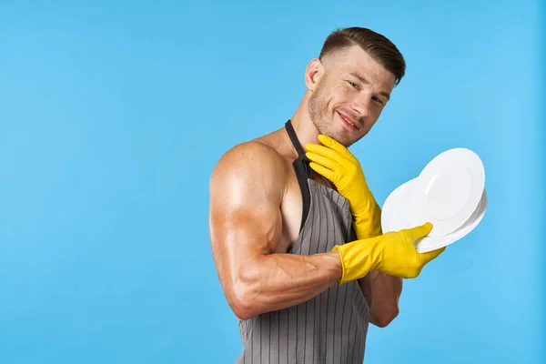 Een man in rubberen gele handschoenen met een bord in zijn handen afwas service — Stockfoto