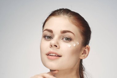 Çıplak omuzlu kadın yüz kremi cilt bakımına yakın çekim