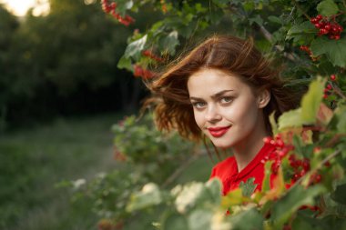 Kırsal alanda kırmızı gömlekli neşeli bir kadın.