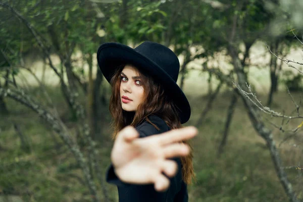 黒の帽子に身を包んだ女が魔法のファンタジーを手に — ストック写真