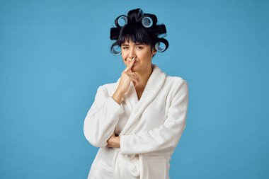 Kafasında bigudilerle ev işi yapan bir ev hanımı.