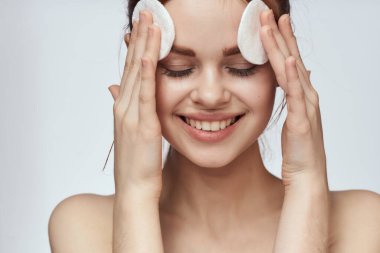 Pamuklu ped ve temiz cilt bakımı cazibesi olan güzel bir kadın.