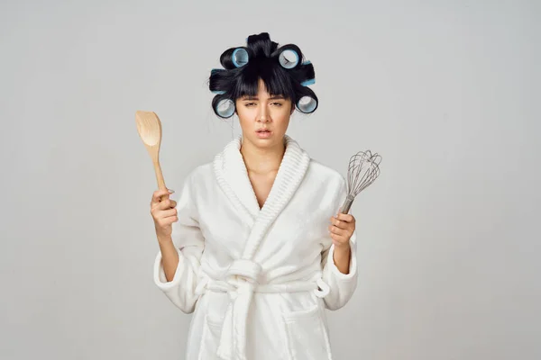 Huisvrouw in witte mantel keukengerei geïsoleerde achtergrond — Stockfoto