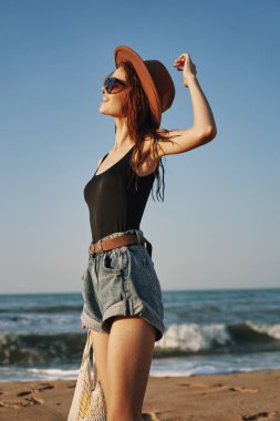 Modayı takip eden yaz elbiseli kadın, okyanus tatilinde güneş altında.