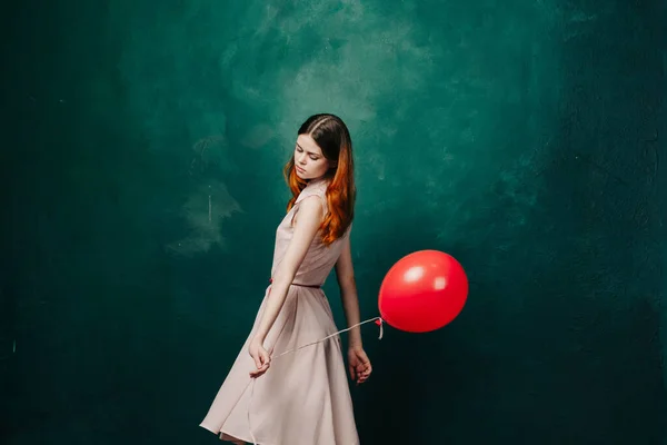 Frau mit rotem Luftballon auf grünem Hintergrund Urlaubsspaß — Stockfoto