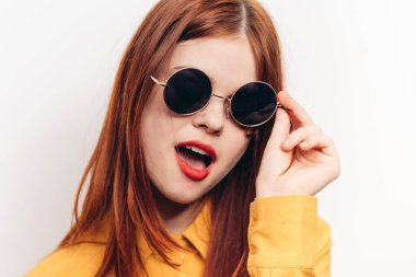 Güneş gözlüklü, kızıl saçlı, çekici bir kadın.