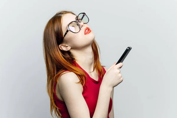 Красивая женщина в очках с телефоном в руках технологии связи — стоковое фото