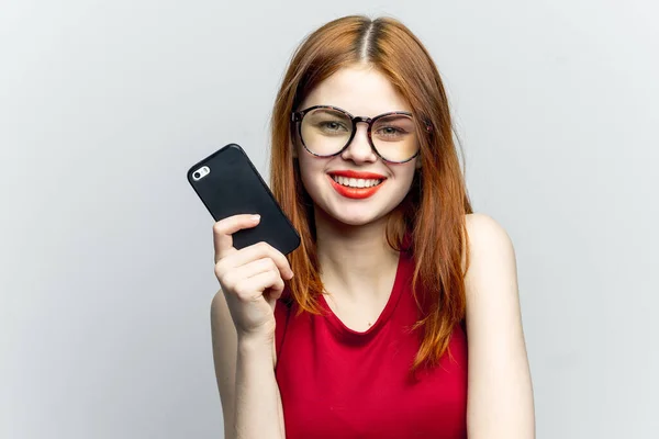 Эмоциональная рыжая женщина с телефоном в руках, связывающим гаджет — стоковое фото
