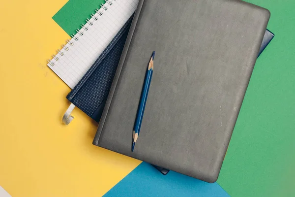 Чорний блокнот олівець барвистий фон канцелярського приладдя — стокове фото