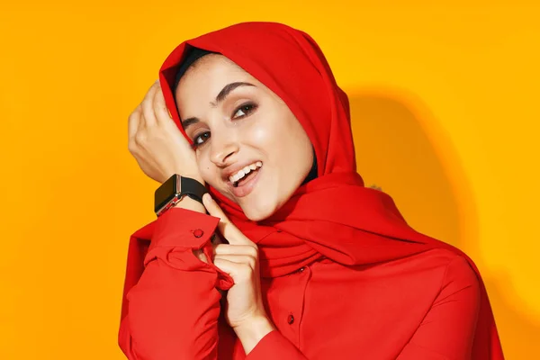Женщина в красном хиджабе с часами в руках технологии эмоции студийный образ жизни — стоковое фото