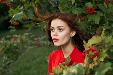 Kırsal alanda kırmızı gömlekli neşeli bir kadın.