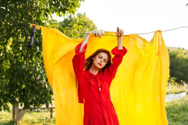 Kırmızı elbiseli duygusal kadın. Sarı arka plan pozu.