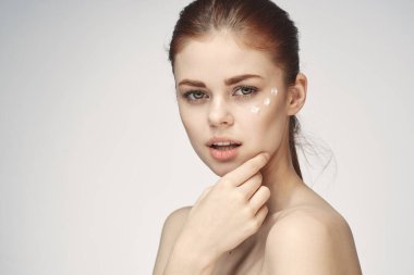 Çıplak omuzlu kadın yüz kremi cilt bakımına yakın çekim