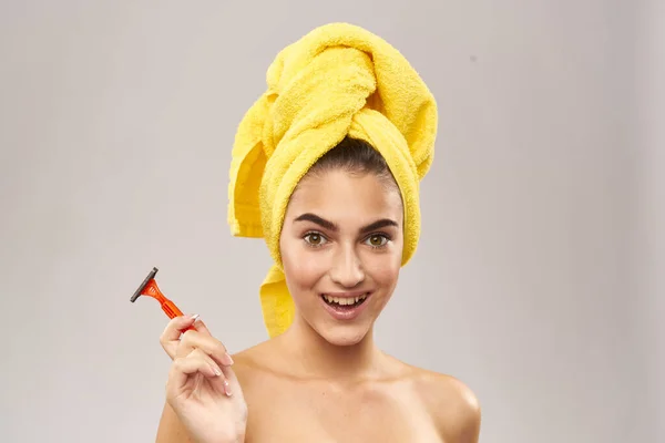 Krásná žena se žlutým ručníkem na hlavě holení — Stock fotografie