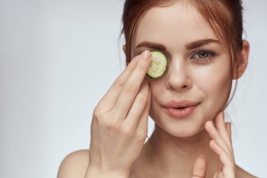 Çıplak omuzlu çekici bir kadın. Salatalık cilt bakımı.