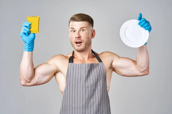Un hombre en un delantal lavado de platos servicio de limpieza — Foto de Stock