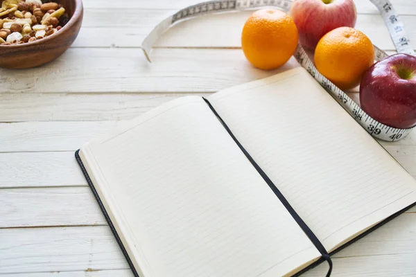 Notepad na stole měřicí páska ovoce snídaně nutriční fitness — Stock fotografie