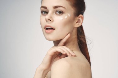 Güzel kızıl saçlı kadın temiz cilt sağlığı açık arka plan pozu veriyor