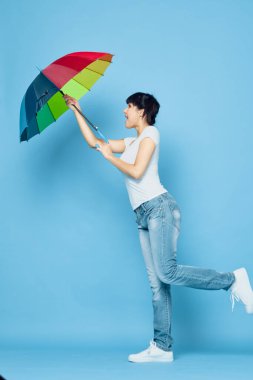 Kırmızı tişörtlü neşeli kadın gökkuşağı renkli şemsiye moda