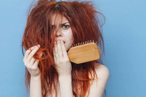 赤い髪の櫛のケアブルーの背景を持つ女性 — ストック写真