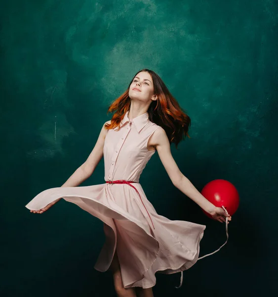 Bonita mujer en vestido rojo globo cumpleaños verde fondo — Foto de Stock