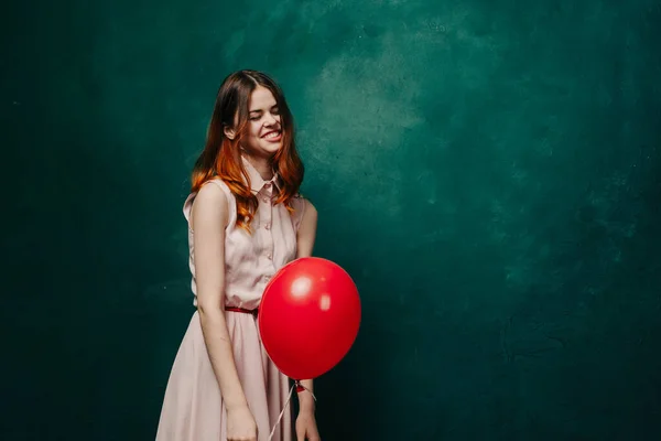 Vrolijke vrouw met rode ballon groene achtergrond vakantie — Stockfoto