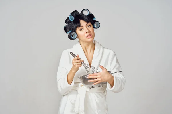 Kvinna i vit rock med papiljotter på huvudet som gör läxor i köket — Stockfoto