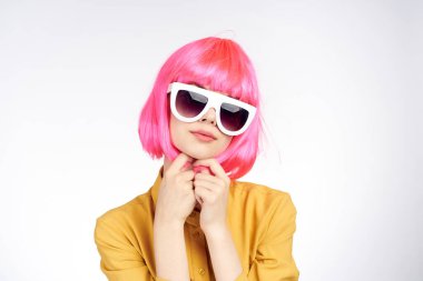 Pembe saçlı, gözlüklü, göz kamaştırıcı bir kadın.