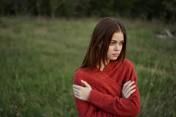 Woman in a red sweater outdoors in a field walk — Stock Photo, Image