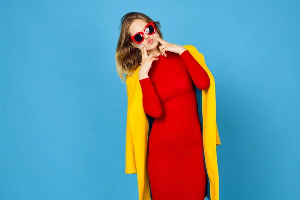 Mujer en chaqueta amarilla posando maquillaje moda fondo azul — Foto de Stock