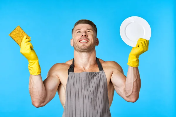 Man in schort reinigen vaatwassen blauwe achtergrond — Stockfoto