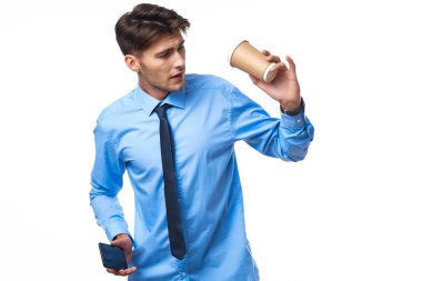 Gömlekli, kravatlı, kahve fincanı olan ofis lambası pozu veren bir adam.