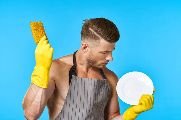 Mann in Schürze reinigt Geschirrspüler blauen Hintergrund — Stockfoto