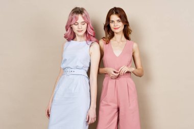 Moda elbiseli iki bayan arkadaş aksesuar stüdyosunun yanında duruyor.