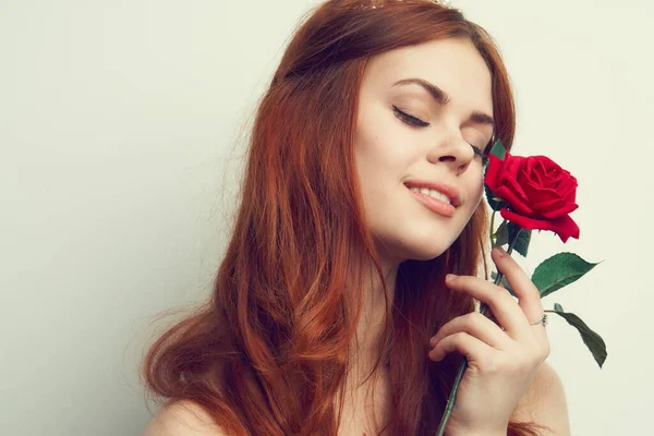 Hermosa mujer con el pelo rojo rosa roja flor de cerca — Foto de Stock